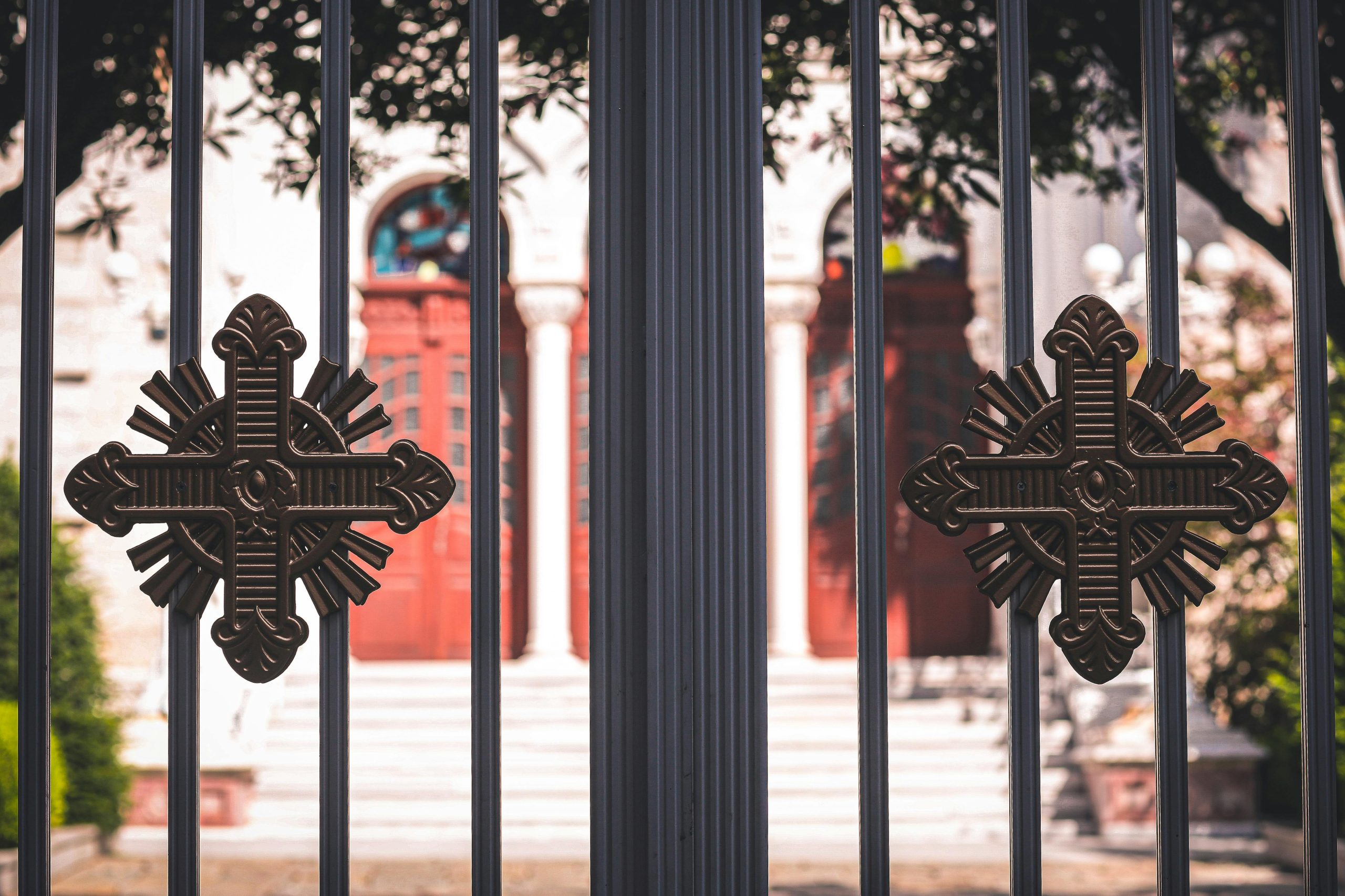 Close-up of a church entrance featuring ornamental metal gates with decorative crosses.